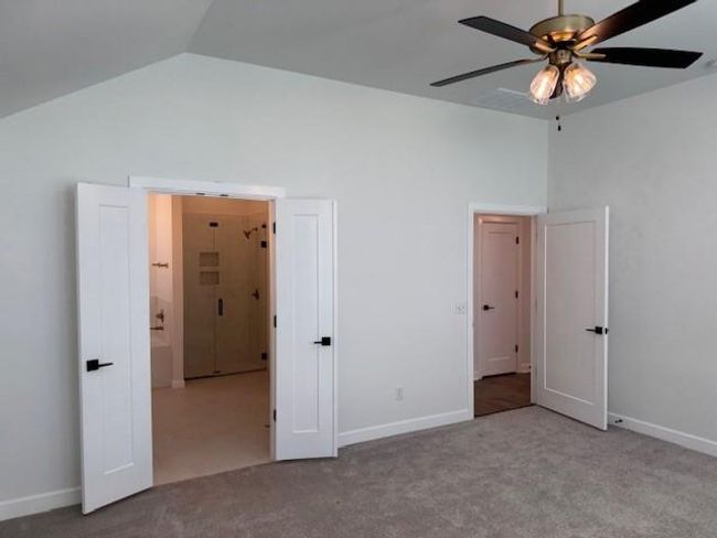 Unfurnished bedroom with carpet flooring, vaulted ceiling, and baseboards | Image 20