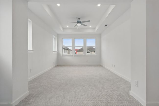 Unfurnished room with a ceiling fan, recessed lighting, light colored carpet, baseboards, and a raised ceiling | Image 22