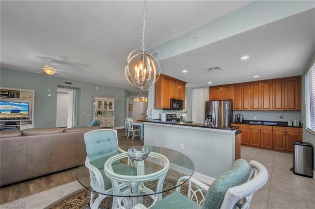 Dining space with a chandelier, light tile patterned flooring, a ceiling fan, and recessed lighting | Image 13