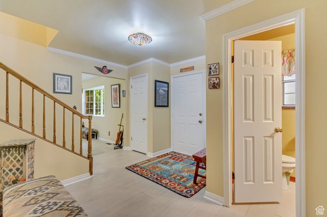 Foyer entrance featuring stairway, baseboards, ornamental molding, and light wood finished floors | Image 19