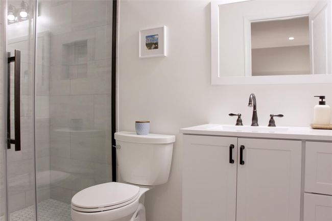 Bathroom with toilet, vanity, and a stall shower | Image 13