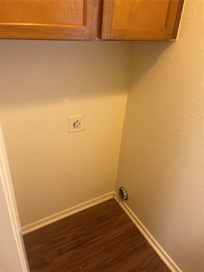 Washroom with cabinet space, electric dryer hookup, and dark wood-style flooring | Image 8