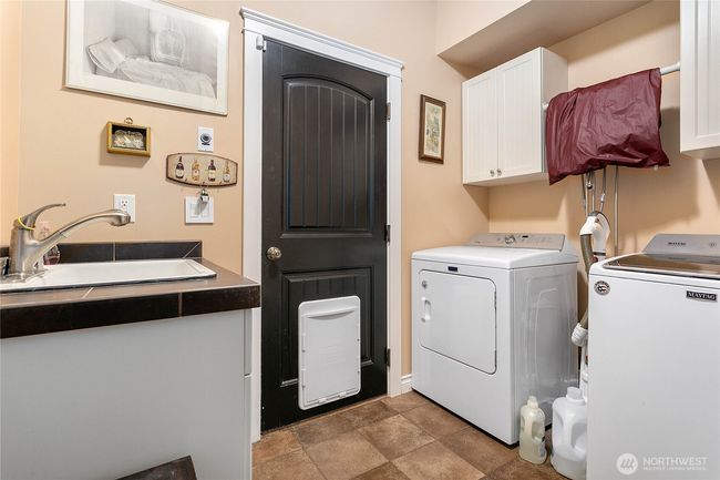 Shared (for now) utility area with storage, washer/dryer, and utility sink. | Image 34