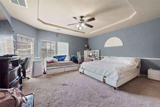 Bedroom featuring a tray ceiling, carpet flooring, and a ceiling fan | Image 18