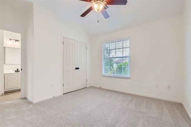 Unfurnished bedroom with light carpet, lofted ceiling, baseboards, and ensuite bathroom | Image 29