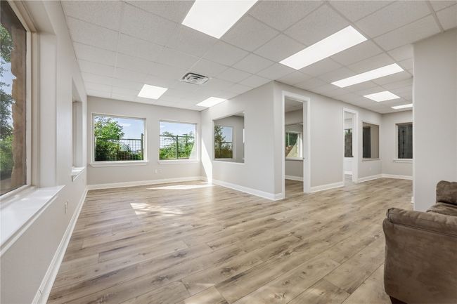 Unfurnished living room with light wood-style floors, a paneled ceiling, visible vents, and baseboards | Image 22