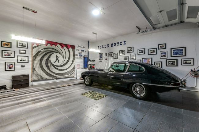 One of two garages, this 2-car garage has been transformed into a car-lovers mancave, with special flooring, an in-laid Rolls Royce flooring design, chandeliers | Image 36