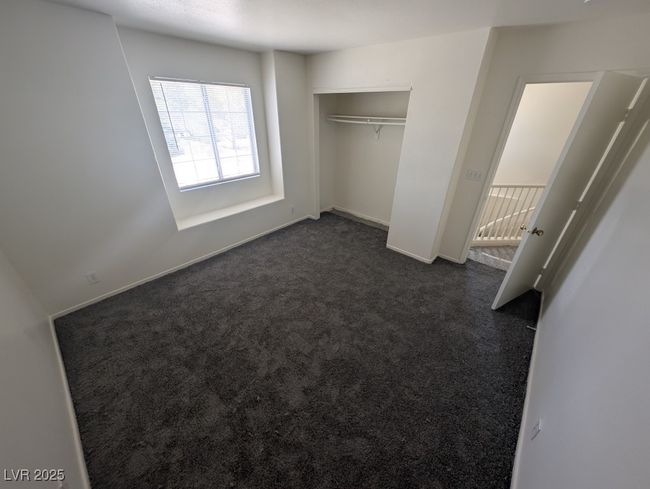 Unfurnished bedroom featuring baseboards, dark colored carpet, and a closet | Image 13