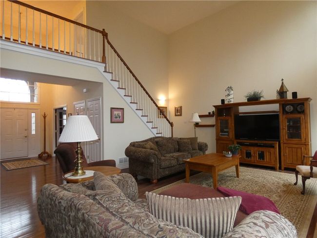 Tucked away to the side of the sprawling great room is the turned staircase to the upper-level loft | Image 23