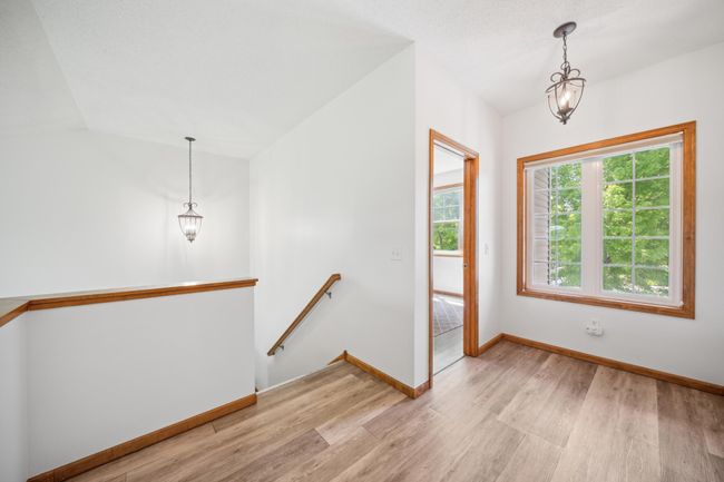 Upstairs are three bedrooms, including a spacious primary suite and laundry. | Image 23