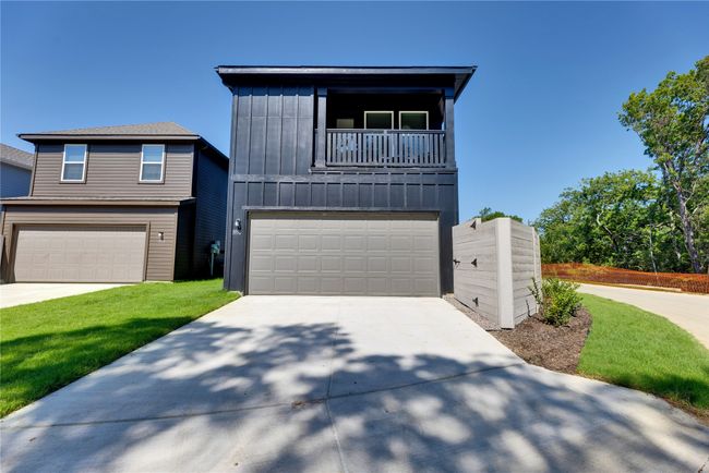 View of front of home featuring driveway, a balcony, an attached garage, board and batten siding, and a front yard | Image 36