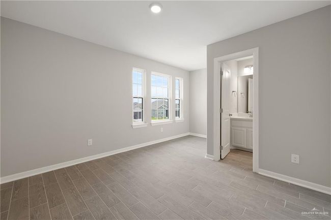Unfurnished bedroom featuring wood finished floors, baseboards, and ensuite bath | Image 8
