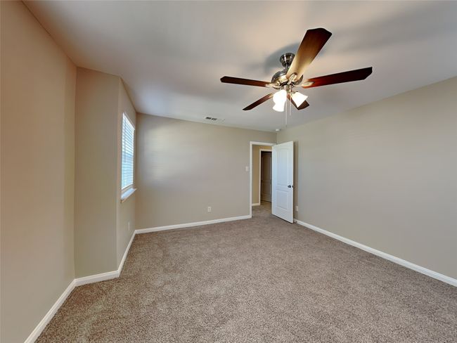 Carpeted empty room featuring a ceiling fan and baseboards | Image 15