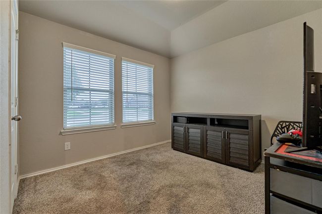 This secondary bedroom has ample closet space and enjoys front yard views. | Image 9