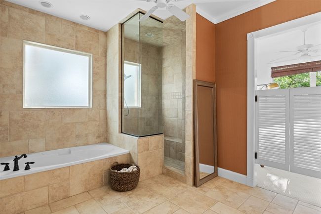 Full bath featuring a bath, a tile shower, a ceiling fan, and crown molding | Image 19