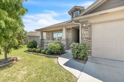 Entrance to property with a yard, covered porch, and a garage | Image 2