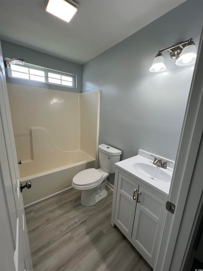 Bathroom featuring vanity, tub / shower combination, and wood finished floors | Image 9