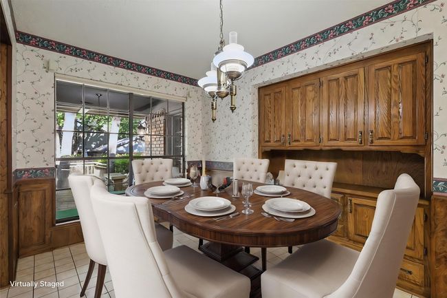 Virtually Staged Dining area with wallpapered walls, a wainscoted wall, and light tile patterned floors | Image 15