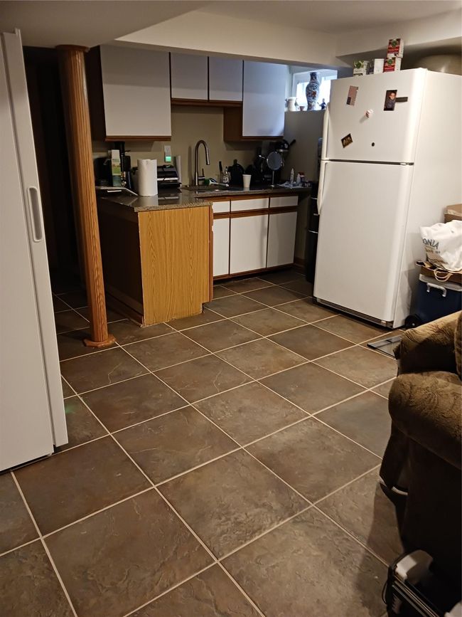 Kitchen featuring dark countertops, fridge, and dark tile patterned flooring | Image 21