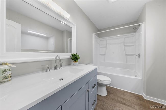 Bathroom with toilet, vanity, bathtub / shower combination, and wood finished floors | Image 16