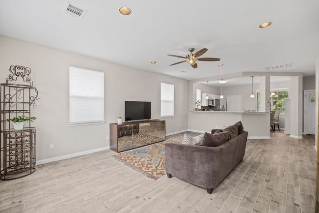 Living area with baseboards, visible vents, ceiling fan, and light wood-type flooring | Image 8