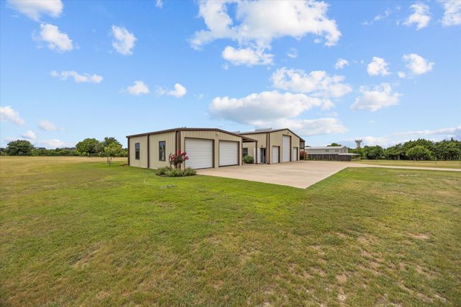 View of front of home with a detached garage, an outbuilding, a front yard, and driveway | Image 6
