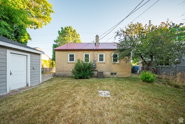 Rear view of house featuring a metal roof and brick siding | Image 8