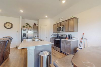 Kitchen featuring sink, appliances with stainless steel finishes, a center island with sink, and light hardwood / wood-style flooring | Image 3