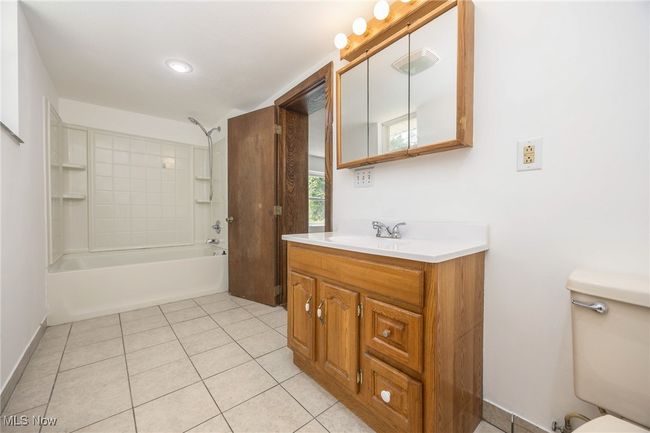 Full bathroom featuring vanity, toilet, tile patterned flooring, and shower / washtub combination | Image 11