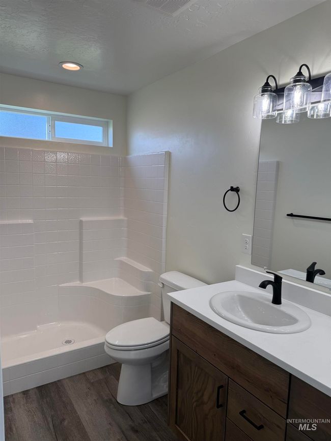 Bathroom with wood finished floors, vanity, and a shower | Image 9