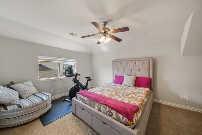 This secondary bedroom has a ceiling fan with lighting, window with blinds overlooking the side yard & carpet. | Image 30