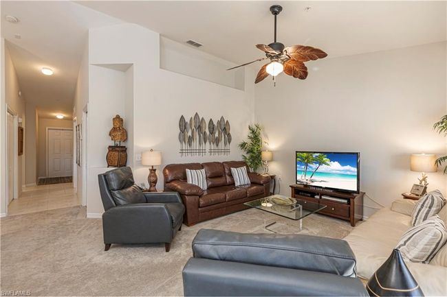 Carpeted living area with a ceiling fan, baseboards, and visible vents | Image 10