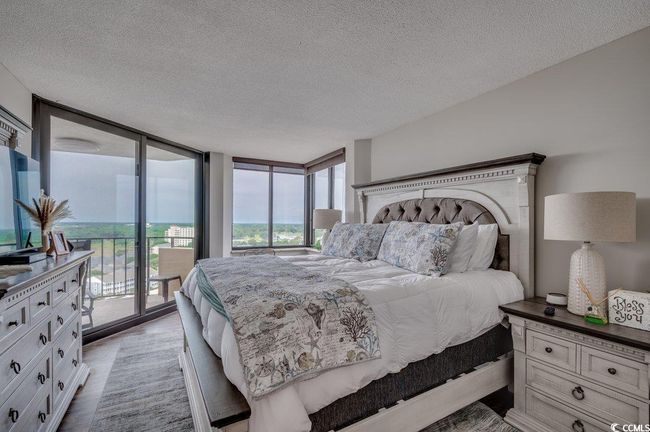 Bedroom featuring expansive windows, a textured ceiling, light hardwood / wood-style flooring, and access to exterior | Image 16