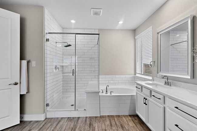 Full bathroom with wood finished floors, a stall shower, a bath, vanity, and recessed lighting | Image 19