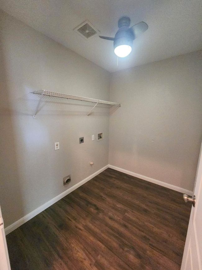 Laundry area with electric dryer hookup, dark wood-style flooring, hookup for a washing machine, ceiling fan, and baseboards | Image 22