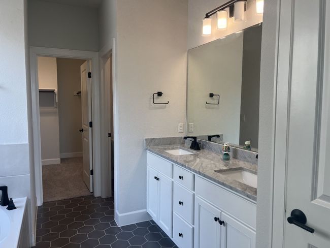 Bathroom with double vanity, a sink, tile patterned floors, and a spacious closet | Image 17