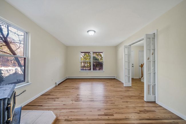Unfurnished room featuring french doors, baseboards, light wood-style floors, and baseboard heating | Image 7