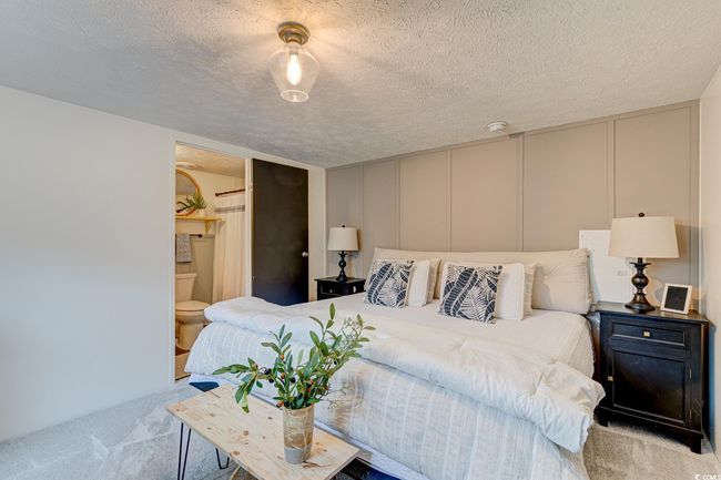 Bedroom featuring carpet, a decorative wall, and a textured ceiling | Image 14