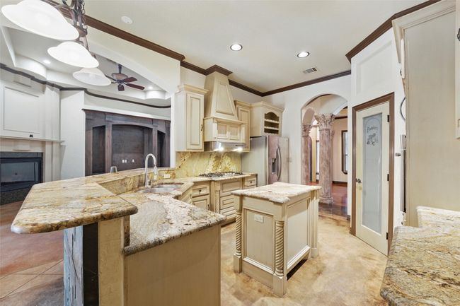 Kitchen featuring a sink, cream cabinets, stainless steel appliances, ornamental molding, and recessed lighting | Image 13