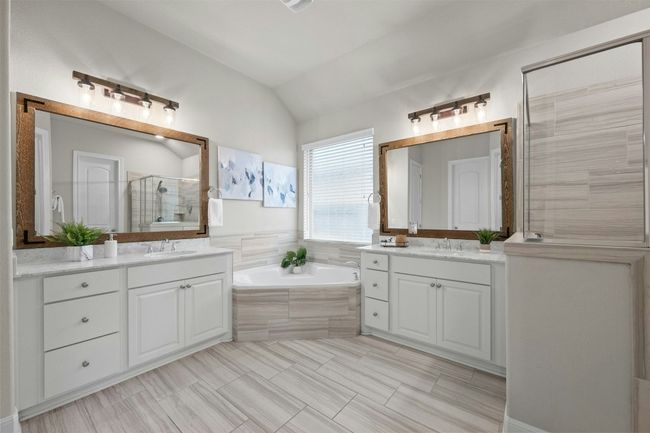 The spa-like en-suite bathroom features dual granite-topped vanities, offering both style and convenience. | Image 18