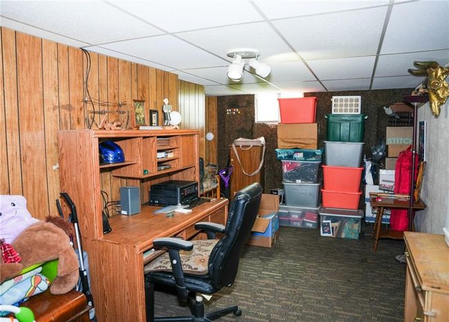 Home office featuring wooden walls, carpet, and a drop ceiling | Image 20