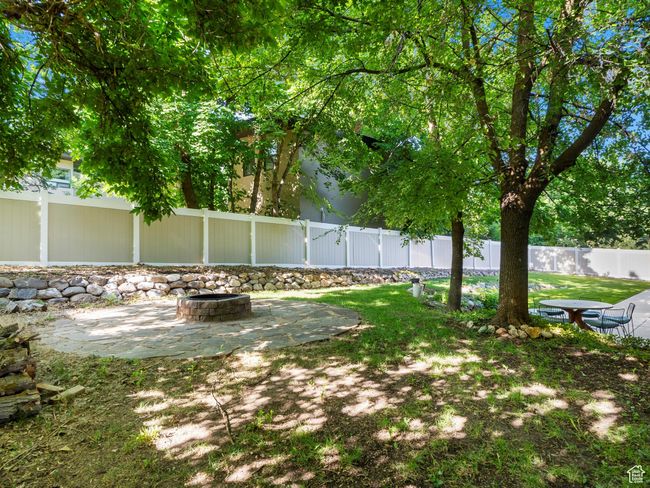 Fenced backyard featuring an outdoor fire pit and a patio area | Image 43