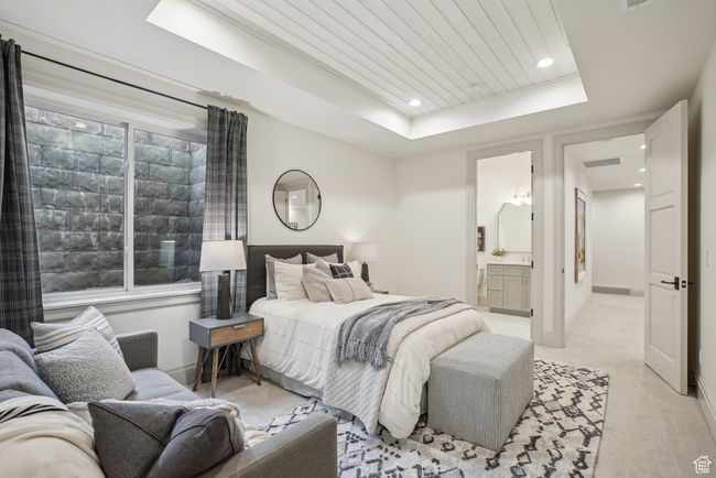 Bedroom featuring a tray ceiling, light carpet, ensuite bath, wooden ceiling, and baseboards | Image 46