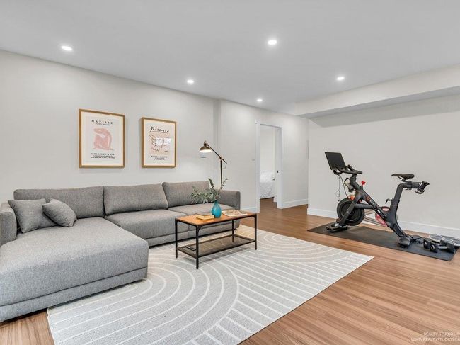 Beautiful newly renovated family room with gas fireplace and statement fireplace surround, built in display shelves as well as enclosed shelving for storage, and beautiful new flooring, all with patio doors to the back yard. | Image 24