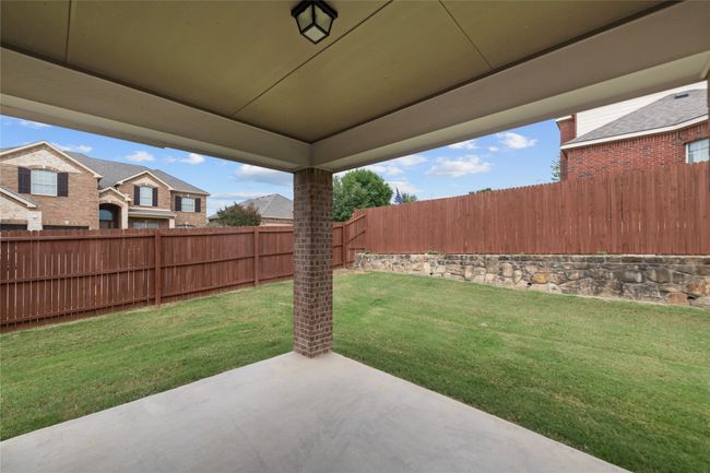 Fenced backyard with a patio area | Image 37