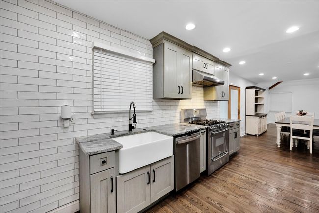 Kitchen with under cabinet range hood, gray cabinetry, stainless steel appliances, and a sink | Image 11