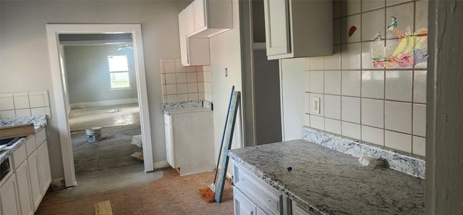 Kitchen featuring decorative backsplash and light stone countertops | Image 10
