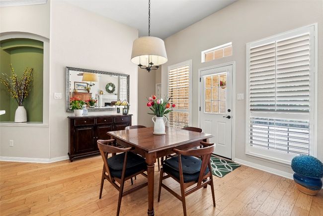 The breakfast area, bathed in natural light from surrounding windows, offers a cozy spot for morning meals while seamlessly connecting to the kitchen and main living spaces | Image 17