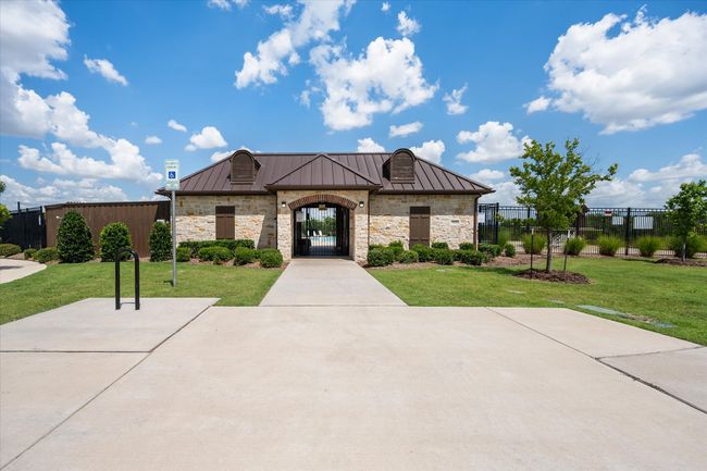 French country inspired facade featuring a standing seam roof, stone siding, and a metal roof | Image 29