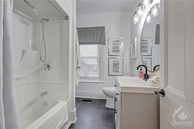 Family bathroom includes easy to maintain tub/shower combo, large window and nook with shelves | Image 21